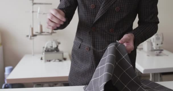 Vista de mãos de alfaiates que cosem uma curva de tecido em um desktop — Vídeo de Stock