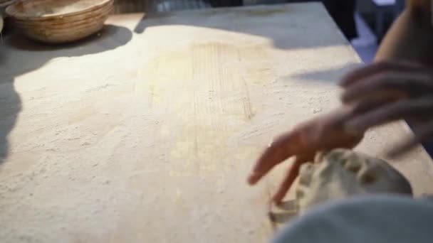 Bakkers handen vormen deeg na geautomatiseerde apparatuur voor brood bakken in een mallen — Stockvideo