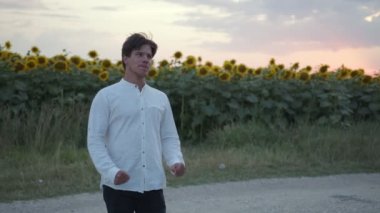 Yakışıklı adam ayakta ve yolda gülümsüyor.