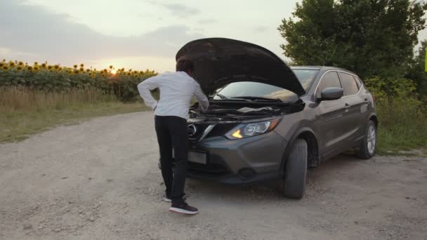 L'uomo cerca di riparare la sua auto da solo sulla strada — Video Stock