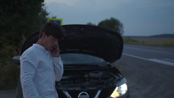 Full man står nära sin trasiga bil på vägen — Stockvideo