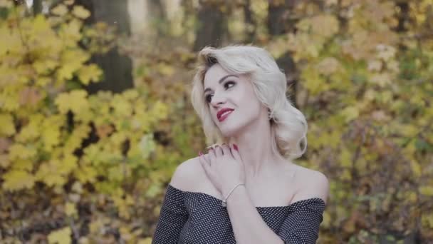 豪華な女性は秋の公園で彼女の肩を愛撫 — ストック動画