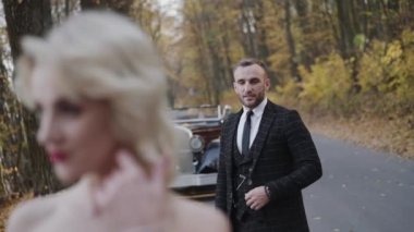 Yakışıklı adam güzel poz veren bayana hayran ve onlar yana bakıyor.