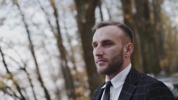 Retrato de hombre feliz confiado mira directamente en el parque de otoño — Vídeos de Stock