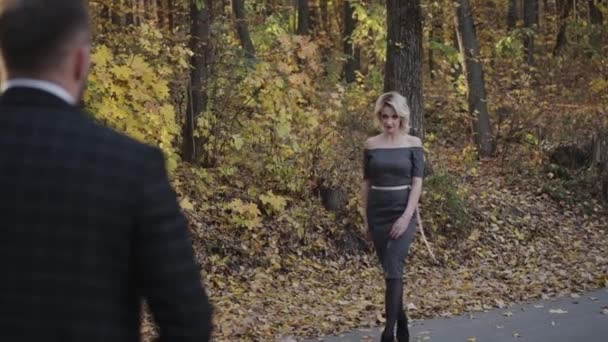 Красивая леди ходит и флиртует со своим джентльменом в осеннем парке — стоковое видео