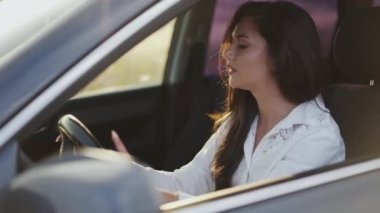 Arabadaki gergin kadın gidonu parmaklarıyla vurur ve kafasını üzerine yaslar.