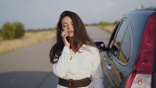 Alleen geïrriteerde vrouw aan de telefoon bij een kapotte auto buiten de stad — Stockvideo