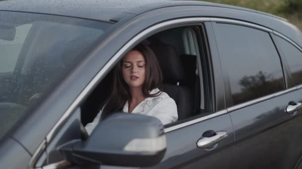 Bezorgde vrouw in de auto klopt op het stuur door vingers en praten in nerveus — Stockvideo