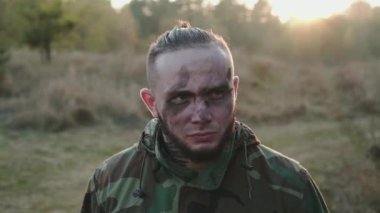 Yüzünde is lekeleri olan asker dikkatlice kameraya bakıyor.