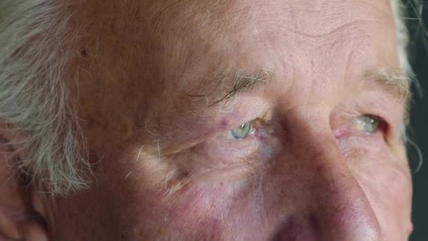 Макро смотрит в камеру пожилого человека с голубыми глазами — стоковое видео