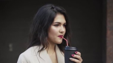 Çekici esmer, tüp boyunca bir bardak içki içer ve saçlarını düzeltir.