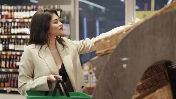 Senhora glamourosa escolhe padaria no supermercado, coloca na cesta e sorri — Vídeo de Stock