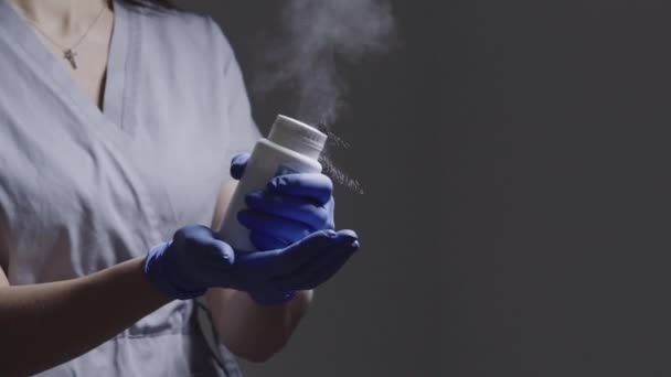 Female masters hands in gloves hits a jar of white powder flying in air — Stock Video