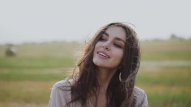 Çekici esmerin portresi. Rüzgarın estiği yerde eğleniyor ve flört ediyor.
