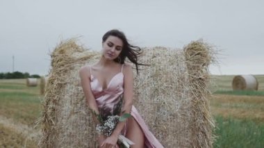 Elinde bir buket çiçekle sakso çeken seksi kadın baştan çıkarıcı duruyor.