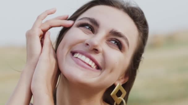 Mulher apoiou-se nas mãos, olhando para o céu e sorrindo luz na natureza ventosa — Vídeo de Stock