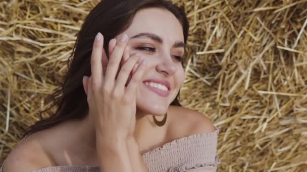 Portrait of stunning brunette laughing gently at camera on hay background — ストック動画