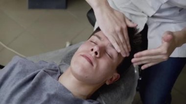 Güzellik uzmanları ellerindeki kremi erkeğin yüzüne masaj hareketleriyle sürerler.