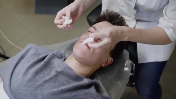 Güzellik uzmanları işlem sırasında erkeklerin yüzlerini pamukla silerler. — Stok video
