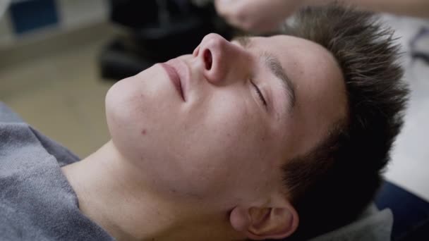 A kozmetikusok kézzel törölgetik a férfi arcát szivaccsal az eljárás során. — Stock videók