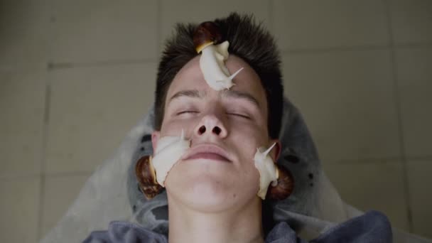 L'uomo che riceve una procedura di ringiovanimento della pelle con chiocciole su faccia — Video Stock