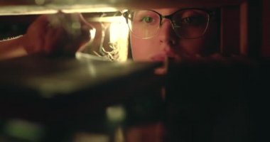 Bir kızın kütüphanedeki rafına bak. Kitabı çıkarıp tozunu alıyor.