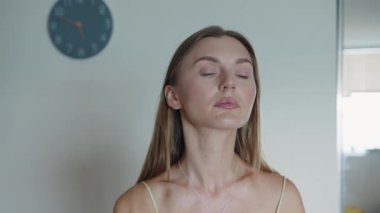 Makyaj fırçası, fırçayla makyaj tozu süren gülümseyen bir kadının yüzü. Stüdyodaki gri arka planda mutlu ve izole. Portre, kozmetik ürün ve modelin tozu, cilt temeli ve yüz güzelliği..