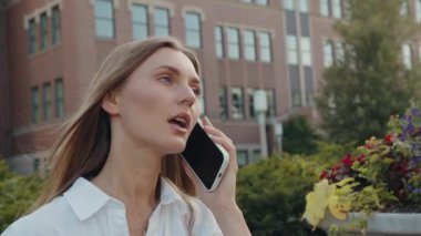 Beyaz bir kadın şehirde yürüyor. Telefon görüşmeleri yapıyor. Çağrılara cevap veriyor.