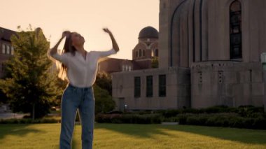 İş kadını gün batımında gülümseyip zıplıyor. 4k