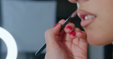 Makyaj sanatçısının, manken dudaklarına ağır çekimde çıplak ruj sürerken yakın plan fotoğrafı. 4k