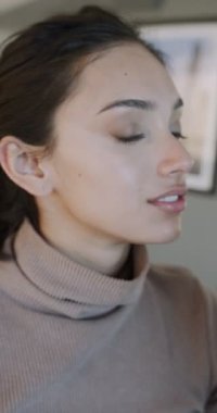 Profesyonel ressam tarafından makyaj yapılan genç Asyalı kadın fırça kullanıyor, yanaklarına, burnuna ve alnına fosforlu toz sürüyor, göze hoş gelen bir renk, kapalı gözler.