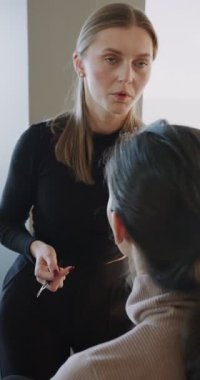 Beyaz makyajcı Asyalı müşteriye parlak stüdyoda ders veriyor, stilist fırça gösteriyor