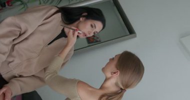 Makyaj sanatçısının güzellik salonundaki bir müşteriye yaptığı yakın çekim hareketi. Güzel model. 4K