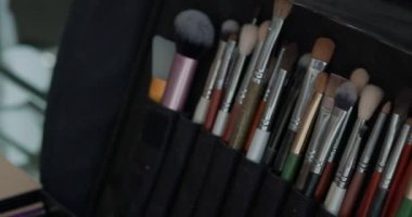 Makyöz, profesyonel fırça setinden fırça alıyor. Güzellik, makyaj ve moda konsepti. 4K