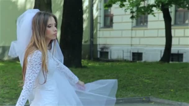 Молодая невеста гуляет в парке — стоковое видео