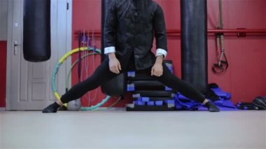 Bir adam siyah bir kimono içinde sicim oturuyor