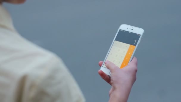 Молодая предпринимательница использует его калькулятор, чтобы получить окончательные результаты компании — стоковое видео