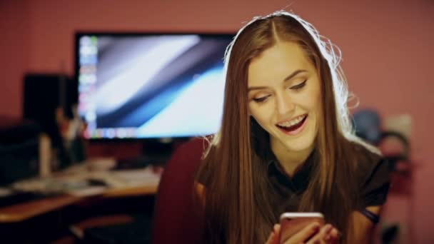 Söt tjej använder sin smartphone på soffan hemma i vardagsrummet Royaltyfri Stockvideo