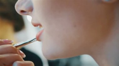 şehvetli genç kadın kozmetik dudaklarının üzerinde uygulama