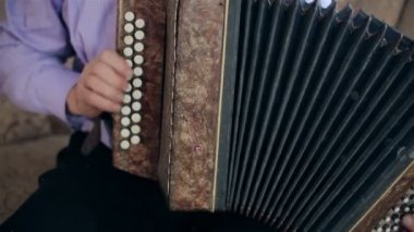 Yaşlı bir adam mızıka çalmaya