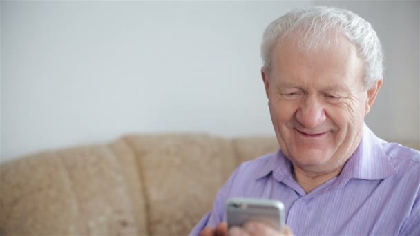 Старик пользуется смартфоном. — стоковое видео