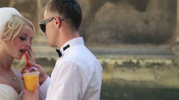 Svatební pár, nevěsta pít pomerančový džus — Stock video