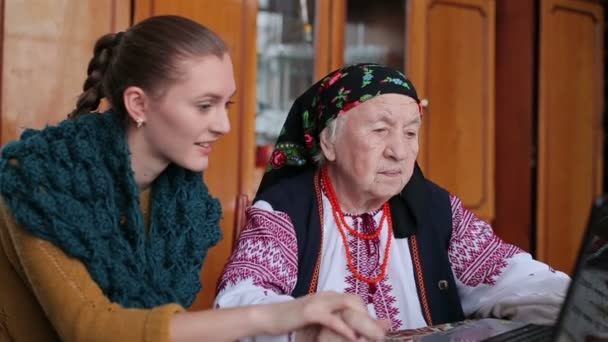 Бабушка с внучкой за ноутбуком — стоковое видео