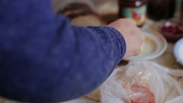 Mujer vieja esparciendo mantequilla en un pedazo de pan — Vídeos de Stock