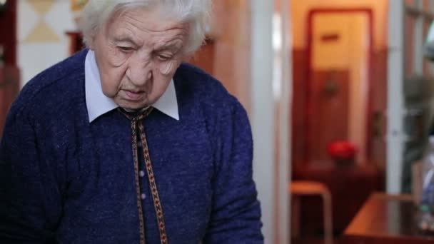 Oude vrouw verspreiding boter op een stukje van het brood — Stockvideo