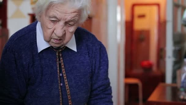 Old woman spreading butter on a piece of bread — Stock Video