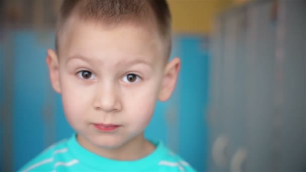 Взгляд в камеру мальчика с большими глазами — стоковое видео