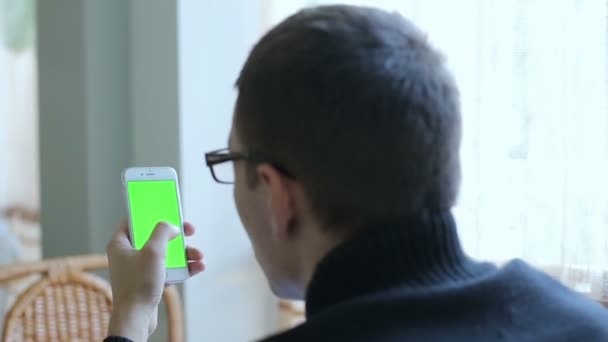 De man in glazen houden een telefoon met groene b — Stockvideo