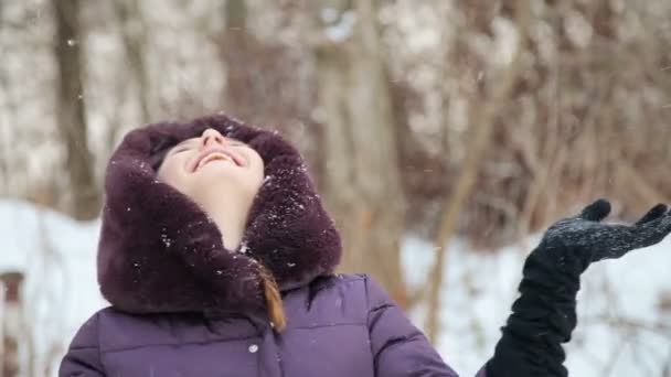 Krásná dívka si hraje s sněhu v zimě — Stock video