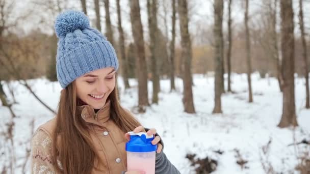 Bebida de proteína menina bonita no parque de inverno — Vídeo de Stock